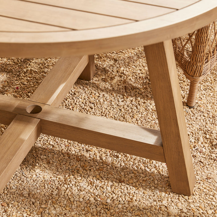 An acacia wood round garden dining with solid cross base