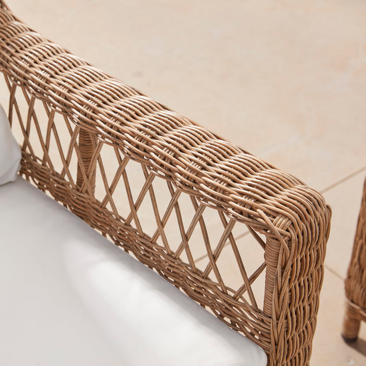 Close-up of and elegant wicker armchair showing the beautiful lattice open weave pattern on the arm.