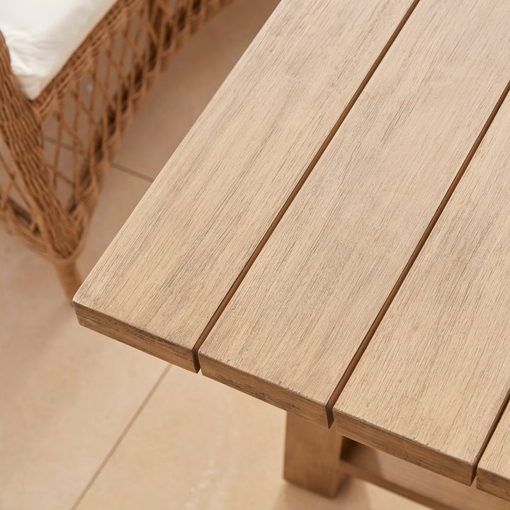 A handcrafted wooden garden table featuring perfectly joined slats and a softened corner