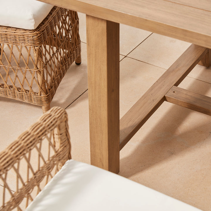 Detail build of a garden acacia wood table, showing solid, beautifully crafted design  against a cotswold patio