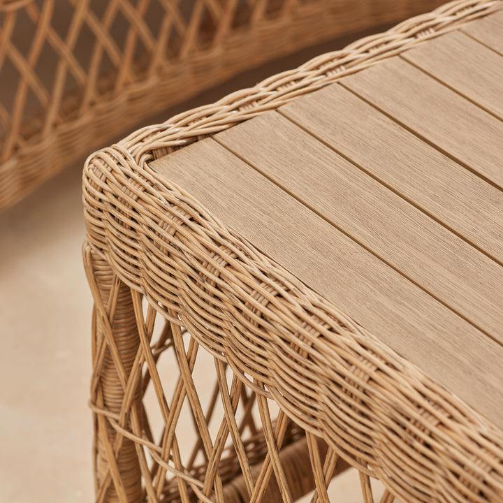 Close up detail of rectangular wooden garden table with a wicker rattan frame