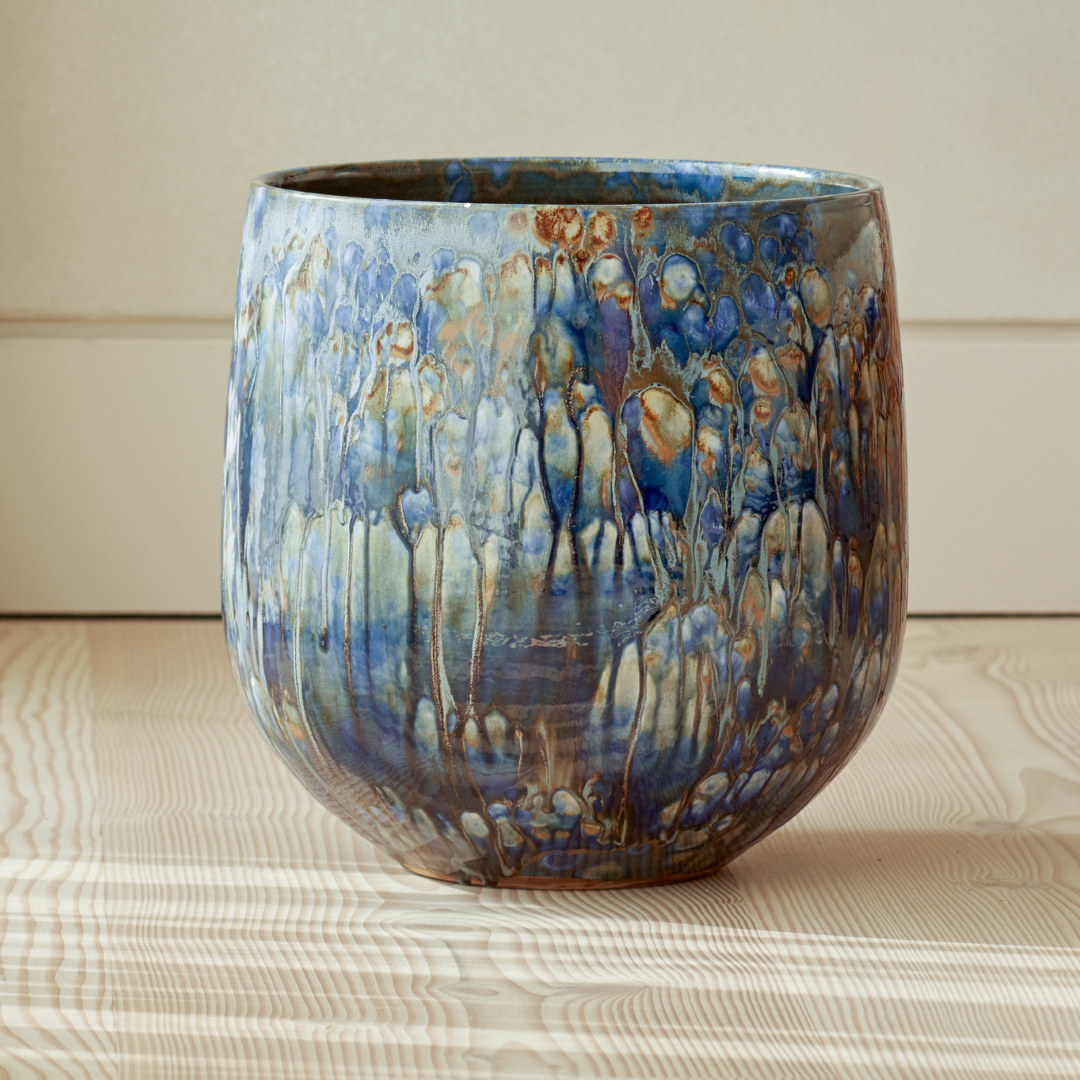 Azura Indoor Plant Pot with a unique, multi-tonal blue glaze, showcasing its sculptural form and glossy ceramic finish.