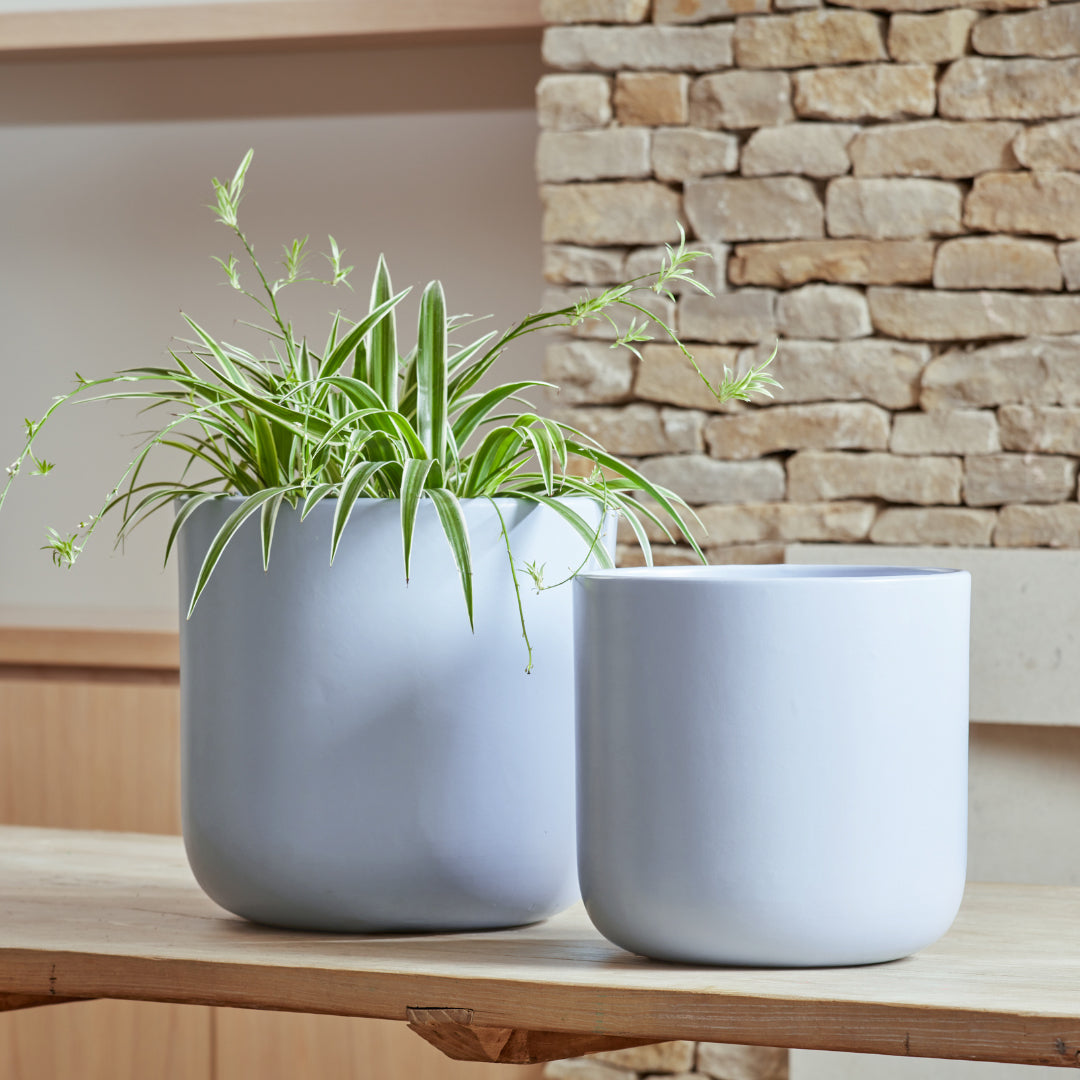 Nova Indoor Plant Pots in light blue and white, displayed together to highlight their smooth, satin ceramic finish.