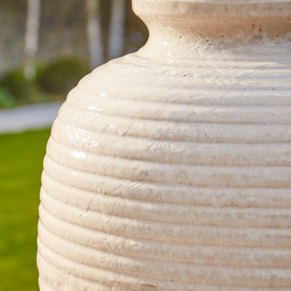 Detail of cream glossy ripple glaze and textured ridges on a tall ceramic urn water feature showing subtle speckled glazing