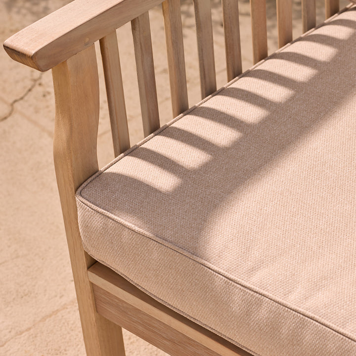 image of neutral woven garden chair cushion and cover with slatted wood arm
