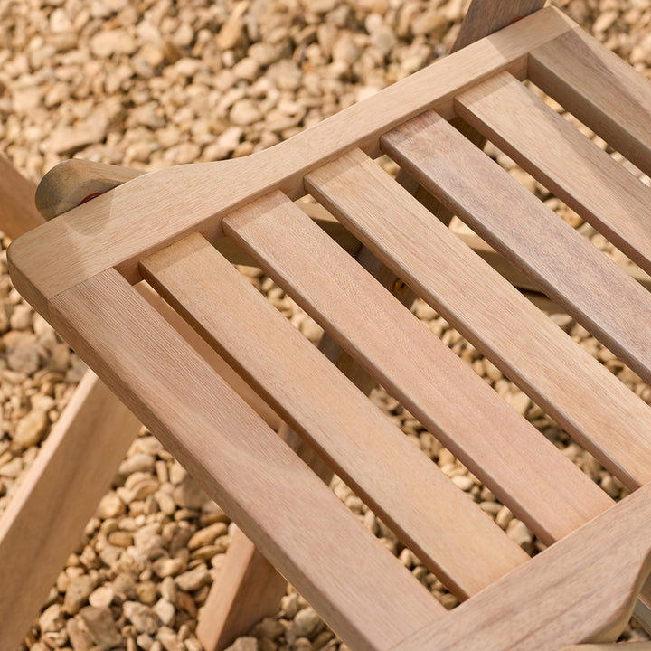 Wooden chair seat on a pebble background