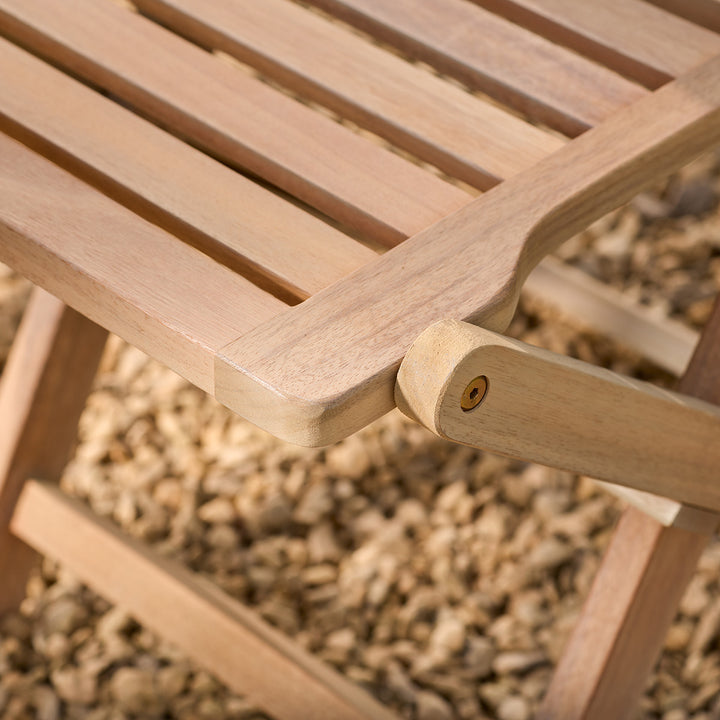 Close-up of a wooden chair with a blurred natural background