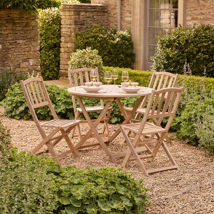 Wooden outdoor dining set with table and chairs in a garden setting.