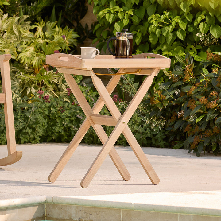 Wooden tray table with a coffee press and cup on a patio