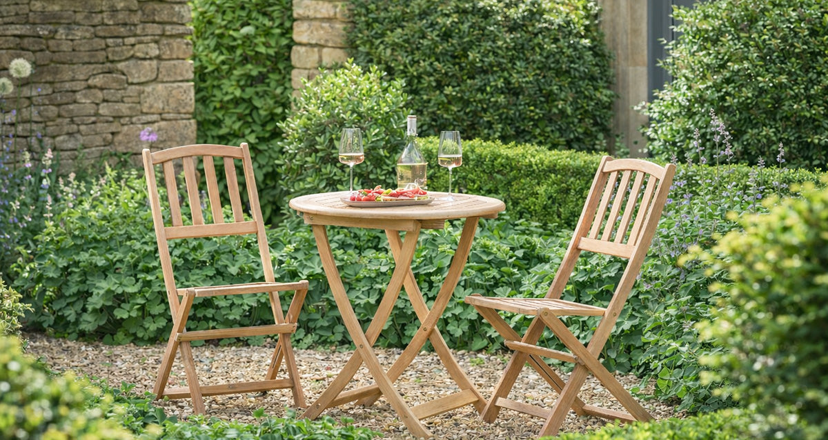 Warm wooden garden bistro set with wine bottle and two glasses, set up for a date in the garden. 
