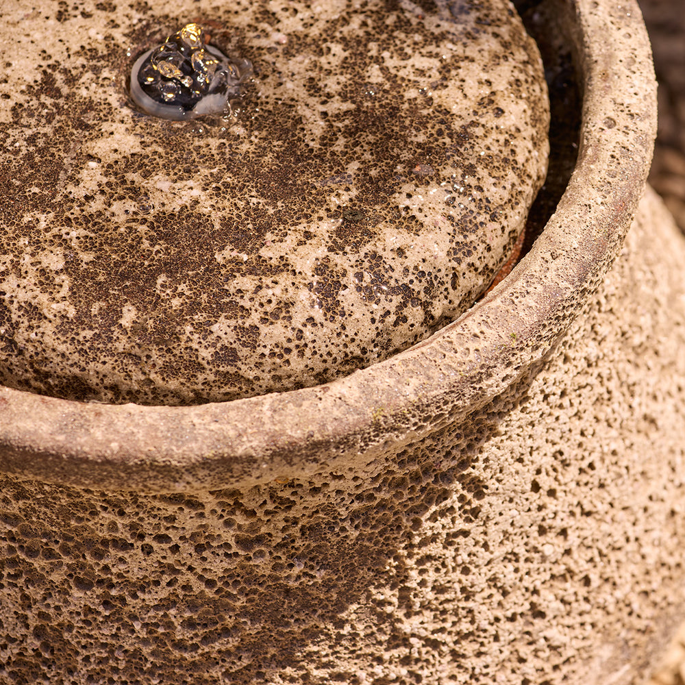 Close-up of a textured garden water feature with a focus on the glaze and surface details.