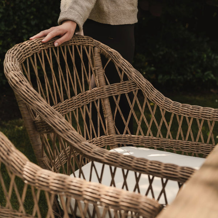Open weave detailed garden dining chair with a person partially visible in the background to show scale.