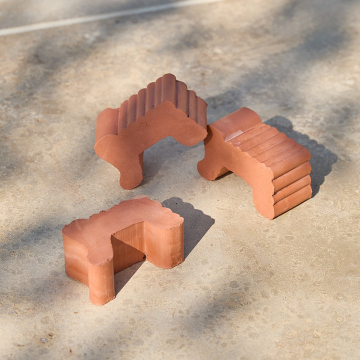 Three terracotta pot feet on a garden patio in natural sunlight.