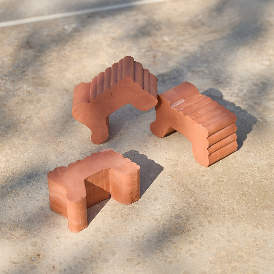 Three terracotta pot feet on a garden patio in natural sunlight.