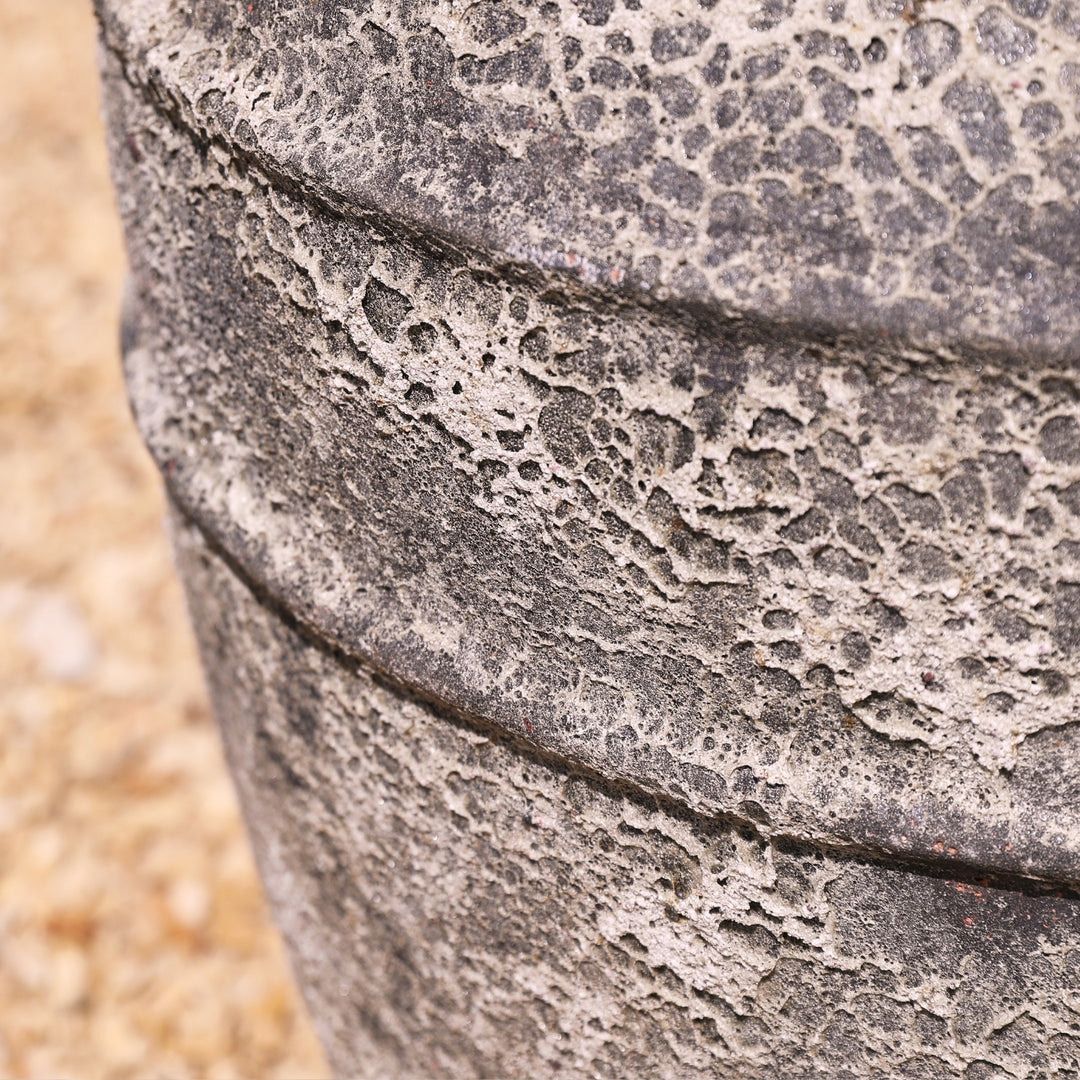 Close-up of a textured stone water feature on a blurred natural background