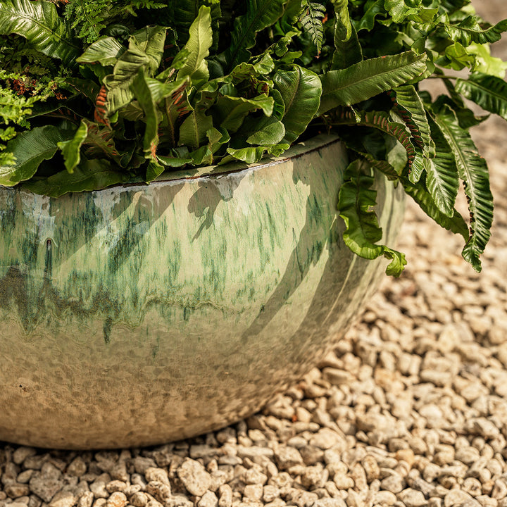 Close-up of Estee green glazed bowl planter showing curved shape and handcrafted reactive glaze finish.