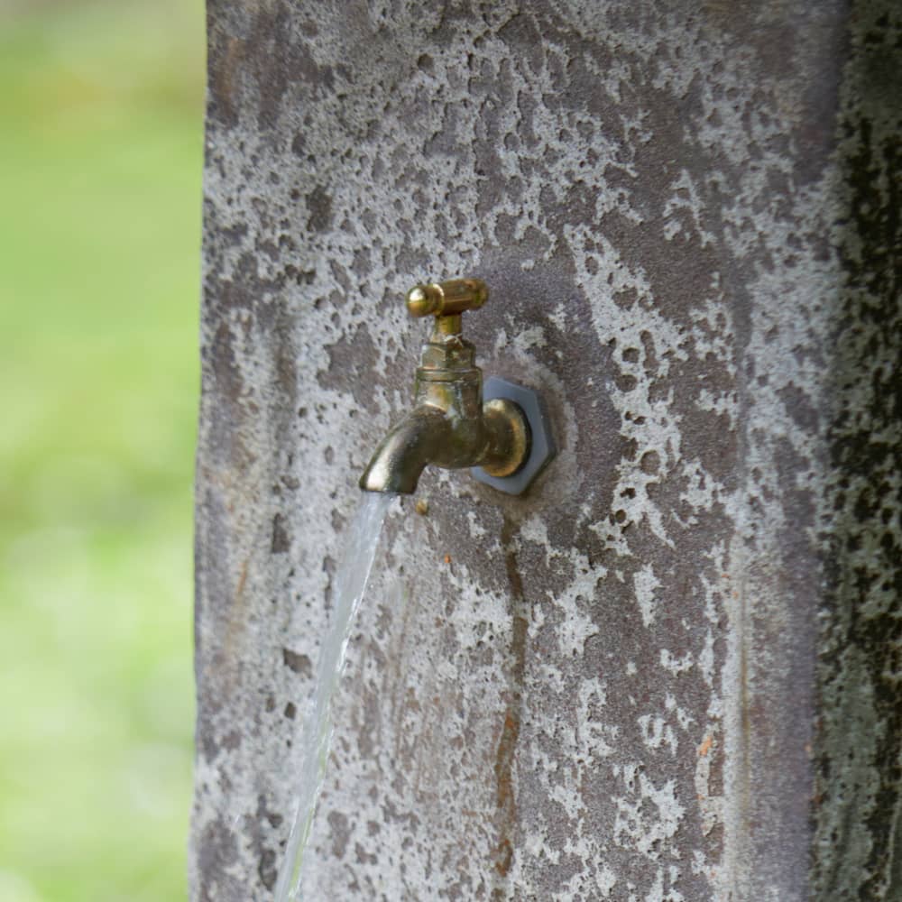 Close-up of the brass tap fixture on the Ancient Stone Garden Fountain, highlighting its vintage-inspired detailing.