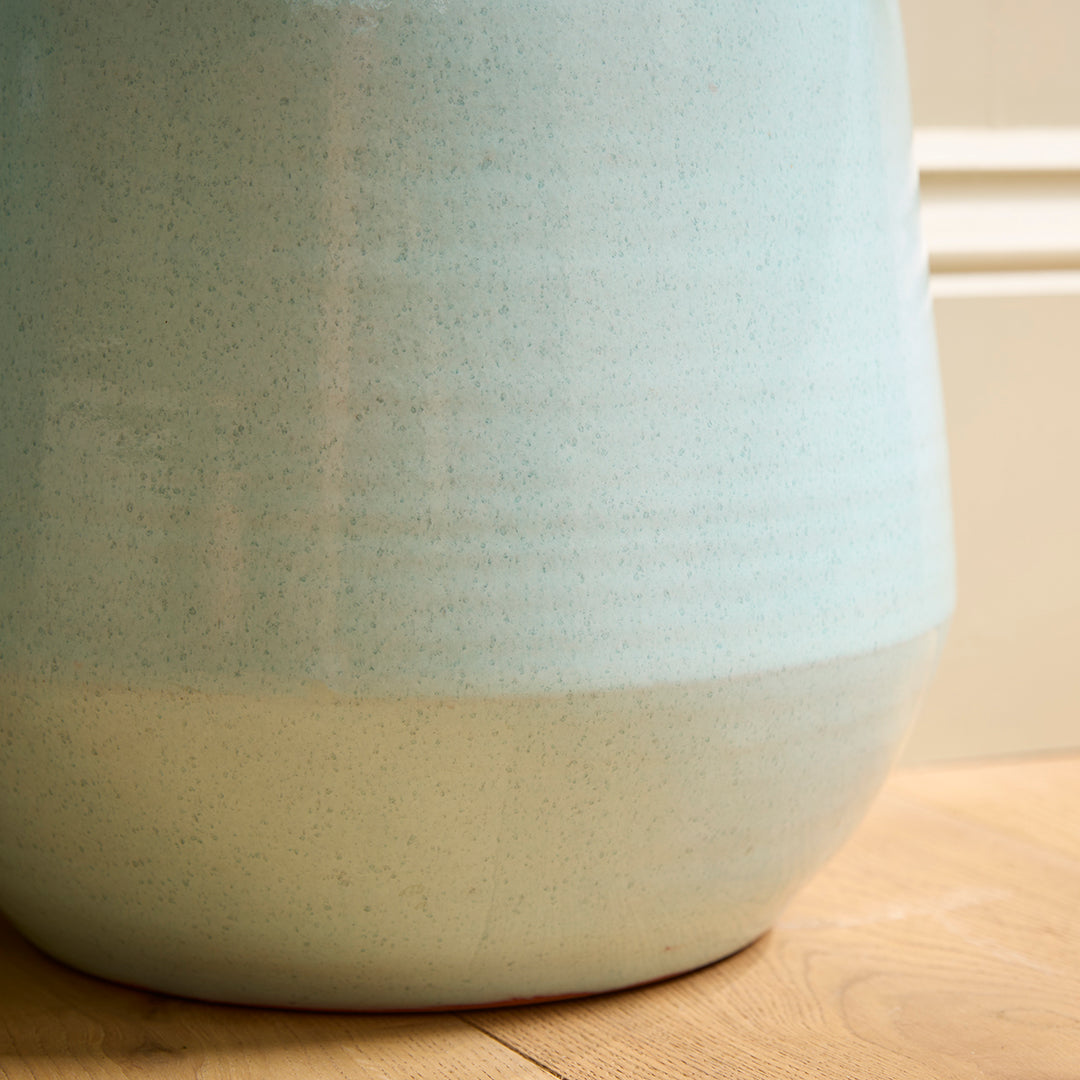 Close-up of a ceramic blue indoor plant pot with two-tone design on a wooden surface.
