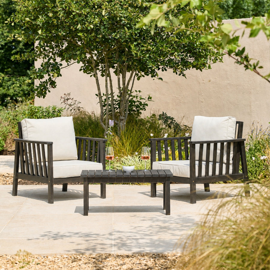 2 wooden armchairs and a side table on a garden patio, finished with a dark black oil stain