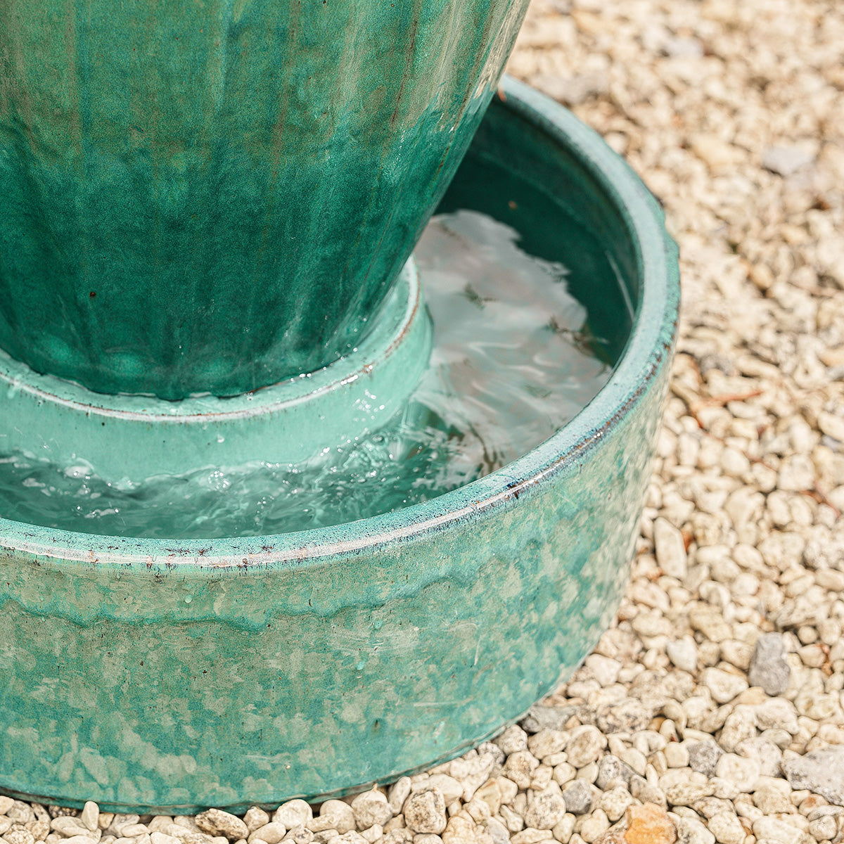 Base of Hera urn water feature showing smooth glaze, water collection bowl, and mains-powered 10m cable design.