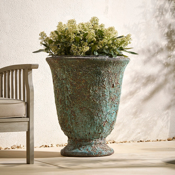 Decorative urn planter with greenery on a patio