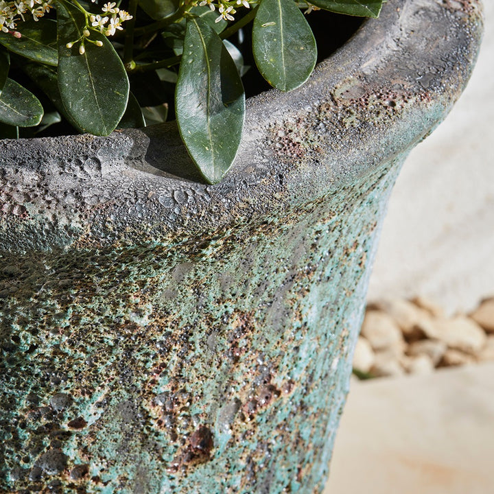 Close-up of a turquoise textured stone planter with greenery