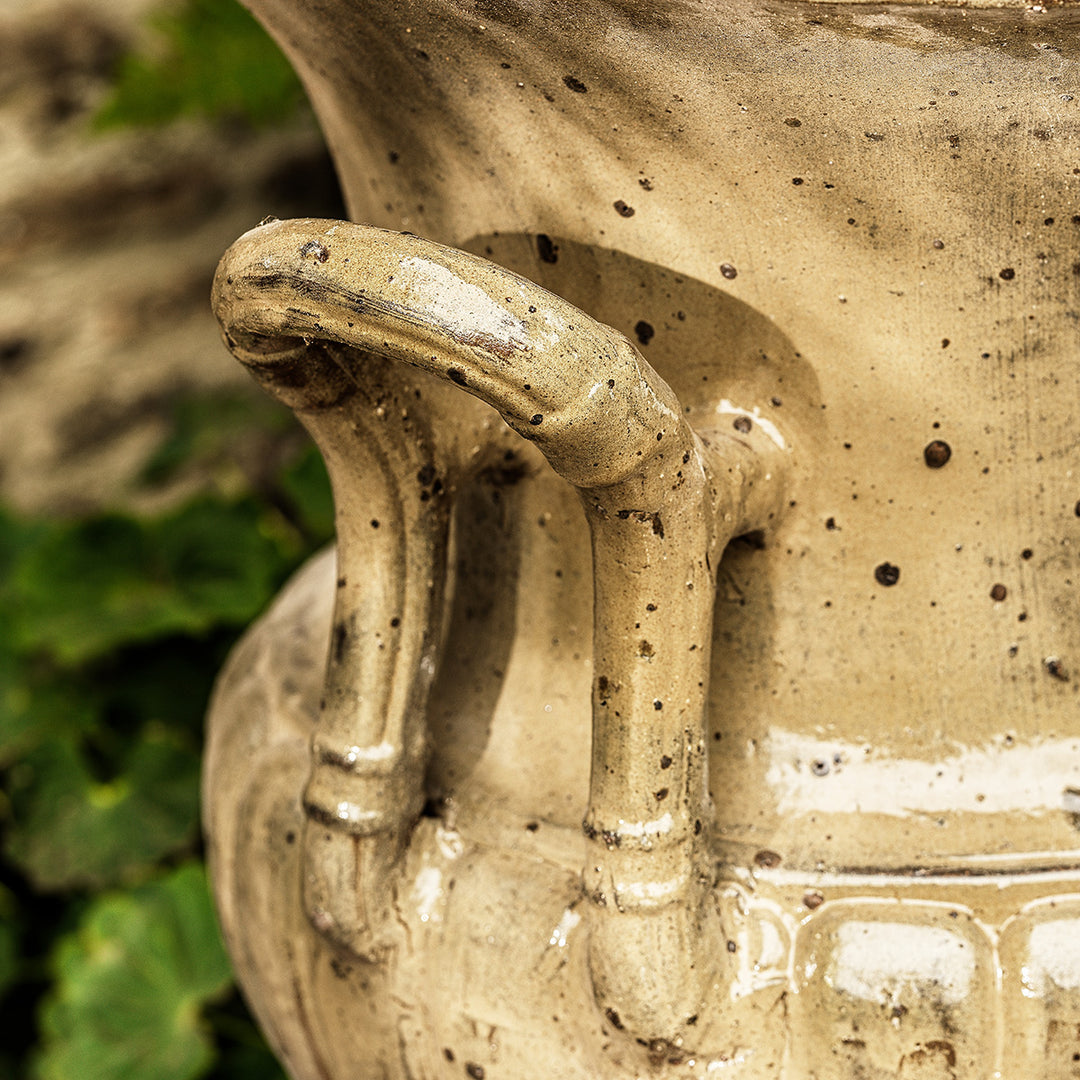 Detailed view of handle on large urn planter in honey glaze, showing textured handcrafted design.