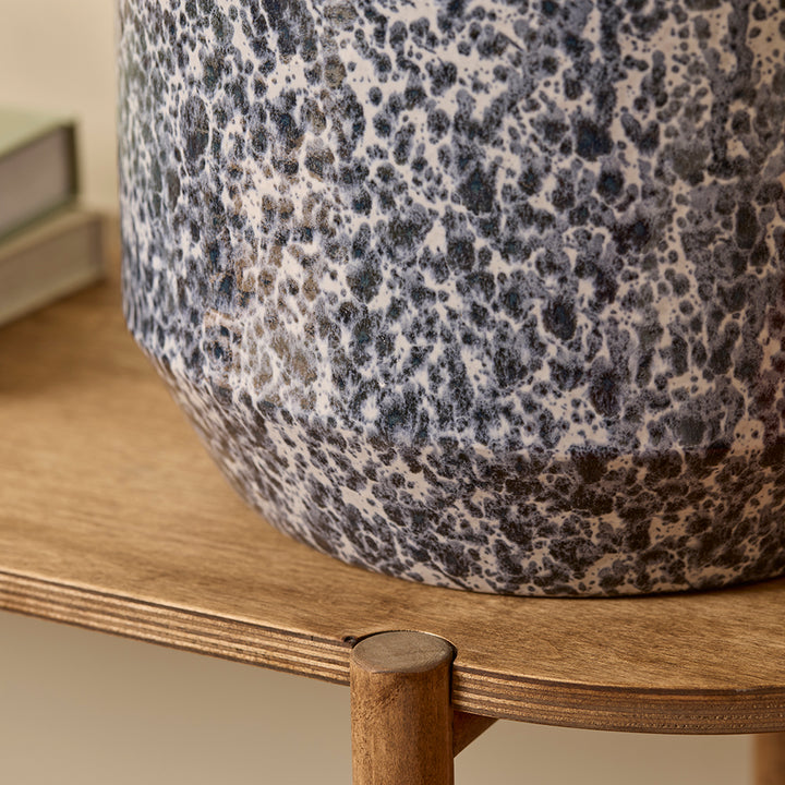 Lotte Indoor Plant Pot close up view of a deep blue glaze mottled with an off white and light blue finish, sat on a wooden table.