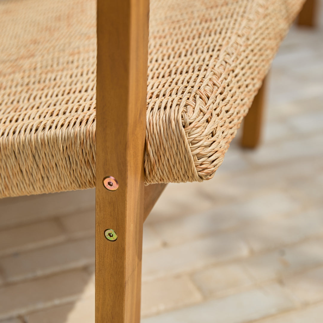 Close-up of a handwoven all-weather wicker chair seat attached to an acacia wood frame showing quality of craftsmanship.