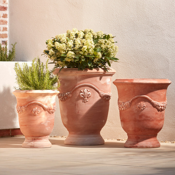 Set of three handcrafted Italian terracotta garden urn planters, perfect for Mediterranean inspired UK garden design