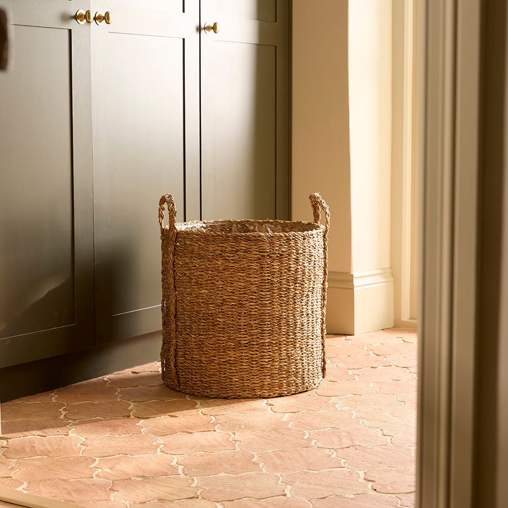 Woven basket on a stone floor with light-colored walls and cabinets.