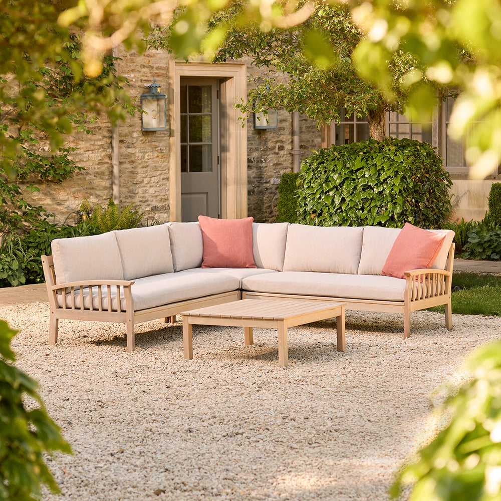 Repton Classic Corner Garden Furniture Set in a natural teak wood colour – a wooden outdoor corner sofa with beige cushions, designed for patios and stylish garden seating. This weather-resistant L-shaped sofa set includes a matching wooden coffee table, perfect for outdoor lounging and alfresco gatherings.
