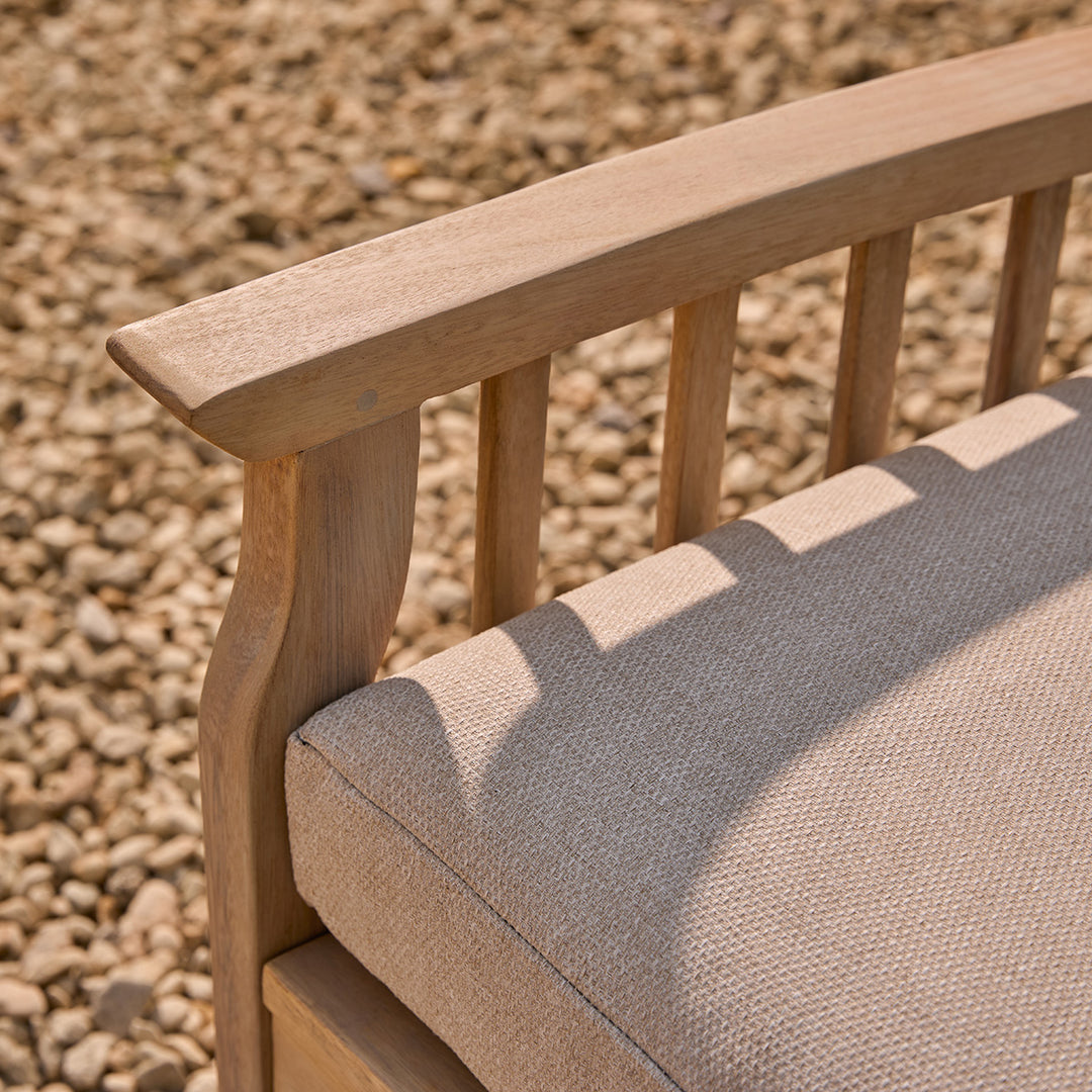 Wooden chair with a water repellant oatmeal cushion against a gravel background