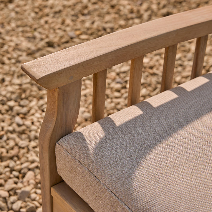 Wooden chair with a water repellant oatmeal cushion against a gravel background