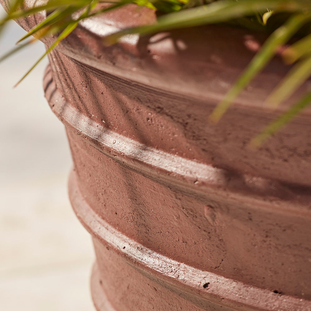 Close-up image of large glazed plant pot in brown with ribbed detailing, showing textured ancient glaze finish