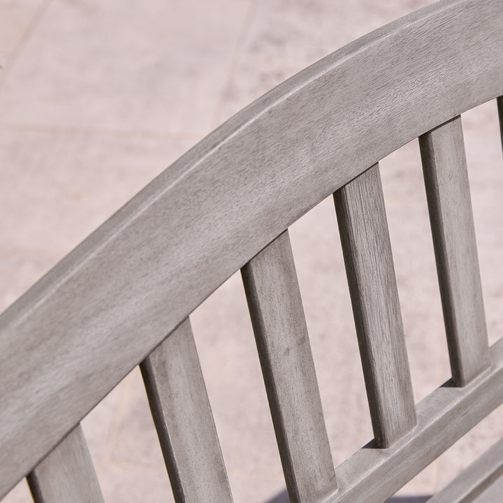 Curved slatted backrest of wooden garden bench in grey eucalyptus finish, showing smooth construction and fine joinery.