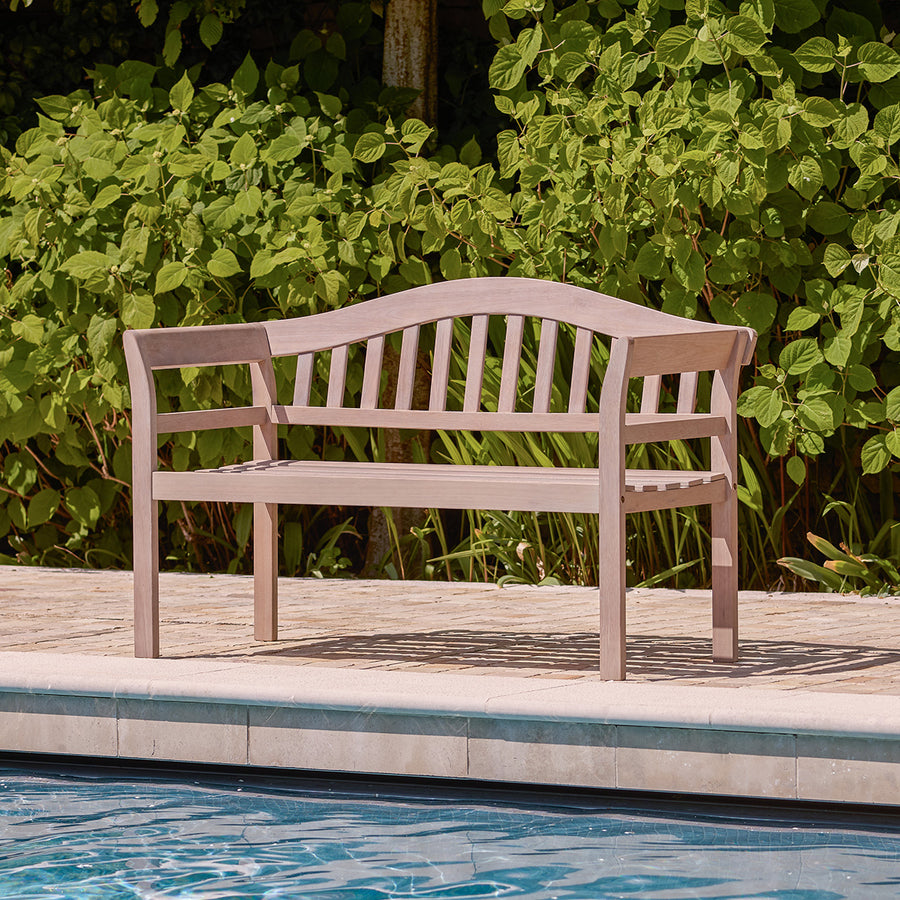 Natural eucalyptus wooden garden bench with slatted back and seat, placed beside a garden pool for outdoor seating.