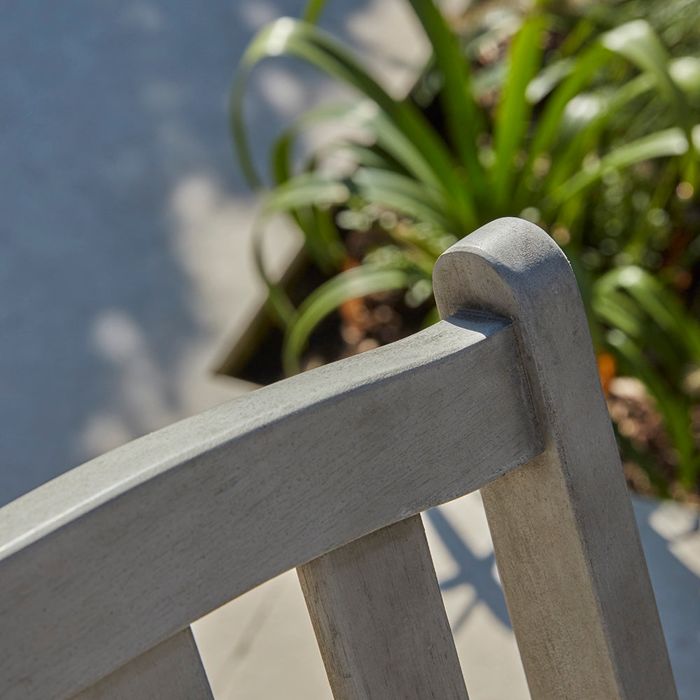 Close-up of the curved top rail from the repton folding wooden garden chair, showing the gentle arch and smooth wood grain.