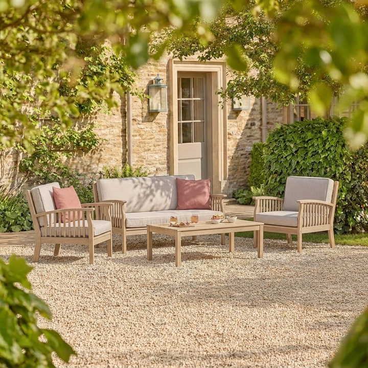 Outdoor patio set with chairs and a table in a garden setting.