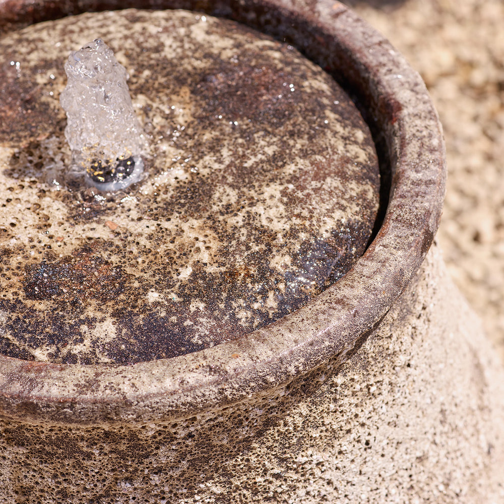 Close-up of a textured garden water feature with a focus on the glaze and surface details.