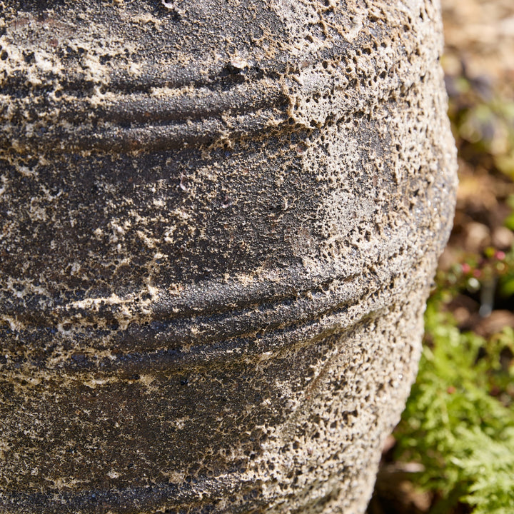 Close-up of a textured stone water feature with natural background