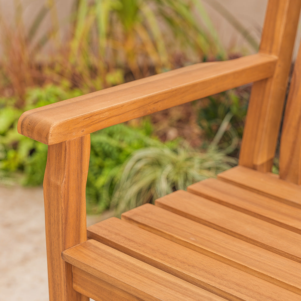 Close-up of a wooden chair with a blurred garden background