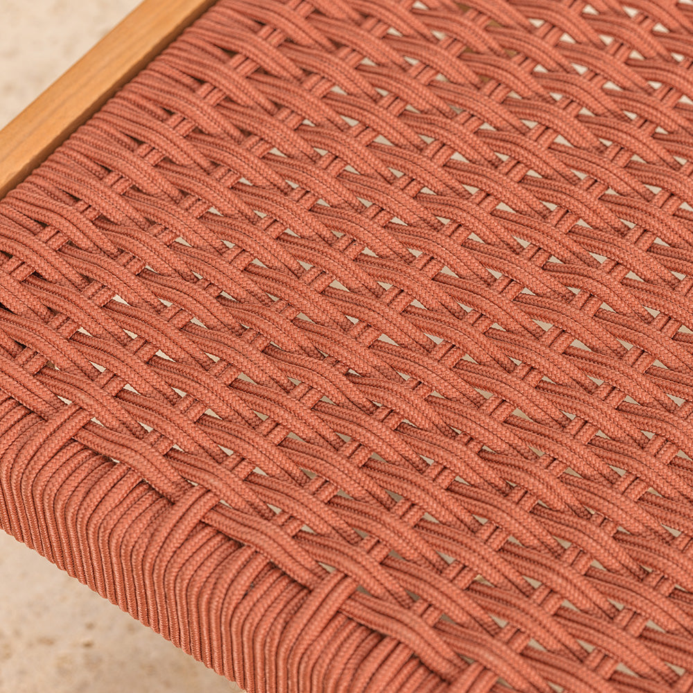 Close-up of a woven red garden chair seat with a blurred background