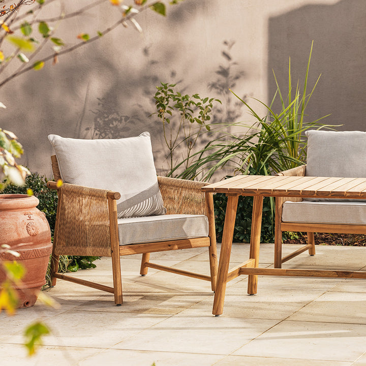 Outdoor patio set with wooden chairs and table on a garden patio.