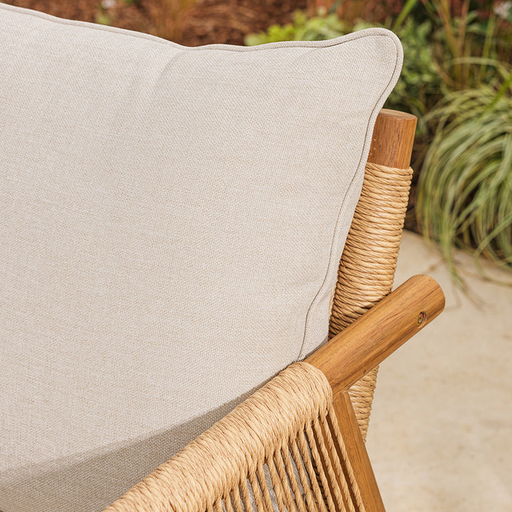 Close-up of a beige cushion on a wicker chair with a blurred natural background
