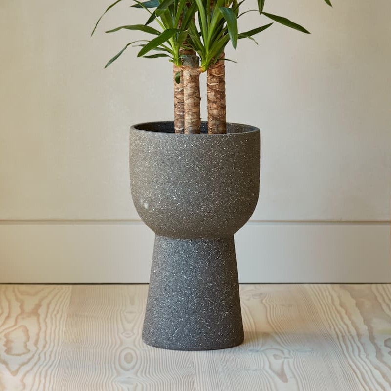 Grey pedestal ceramic planter, Tomi, with a sandblasted textured finish. Ideal for statement plants and contemporary interiors. Handmade in Portugal.