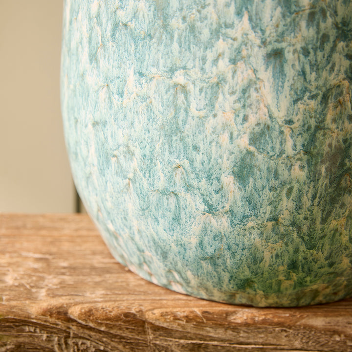 Green marble-patterned vase on a wooden surface