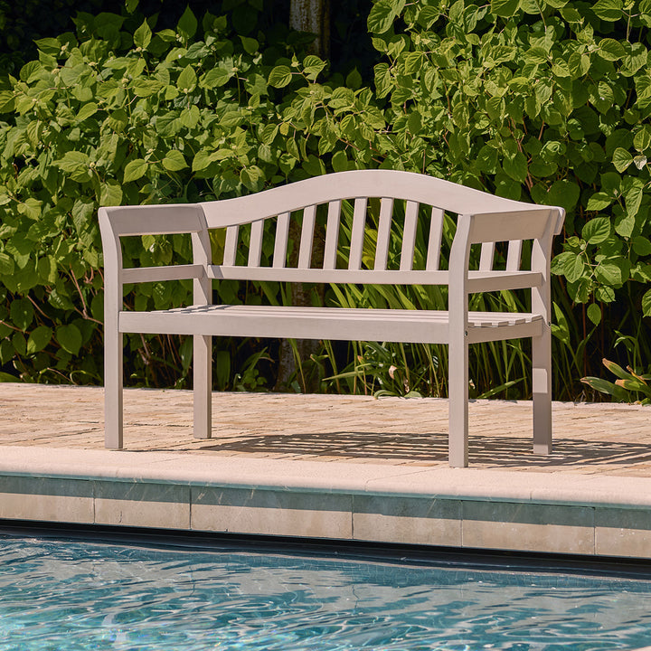 Outdoor 2 seater bench in a light cream grey wood finish placed beside a swimming pool, ideal for garden or patio seating.