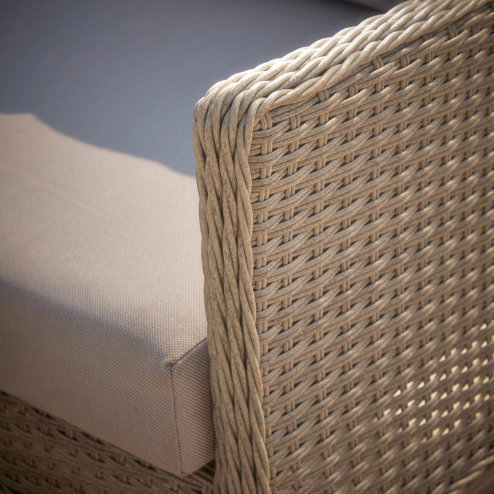 Paxton armchair backrest with intricate woven rattan pattern, paired with a soft, weather-resistant cushion for stylish and comfortable outdoor seating.