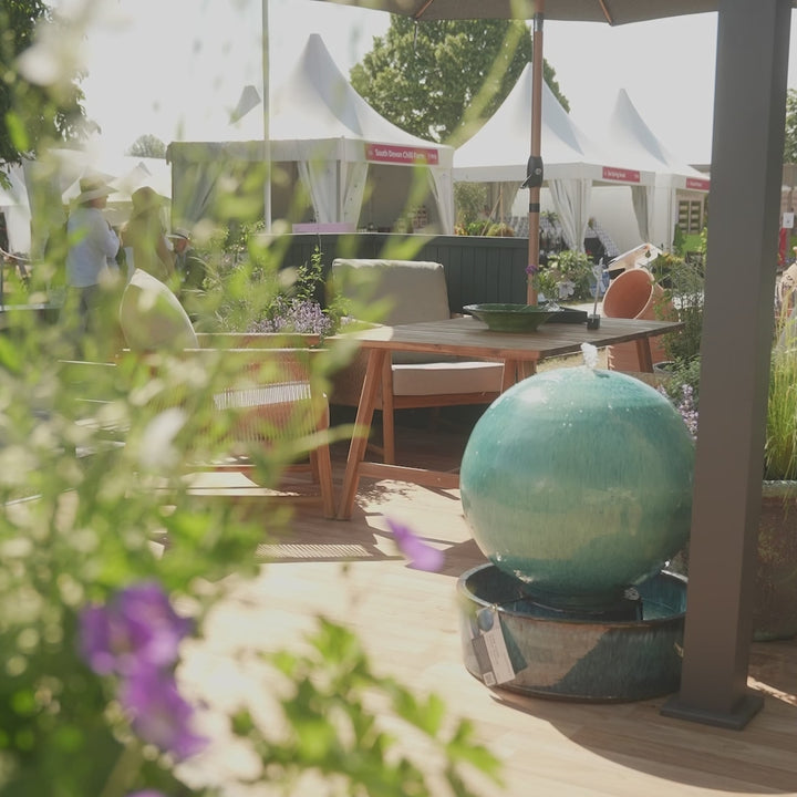 Customers enjoying the Stanley 4-seater casual dining set at the RHS Badminton Flower Show, featuring all-weather wicker, an acacia wood frame and deep, comfortable seats.